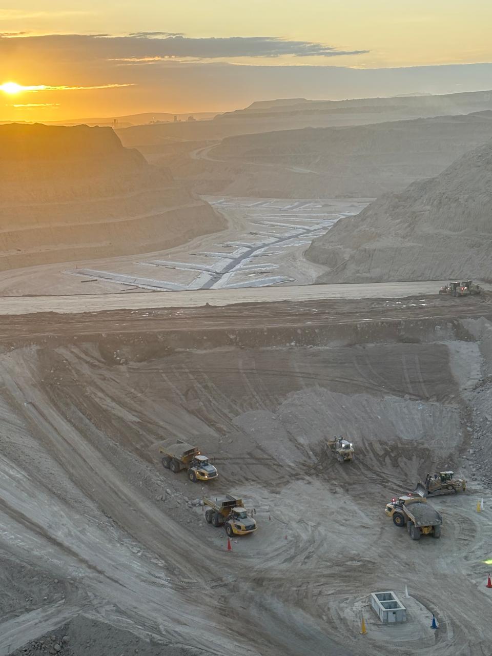 Exposed coal seam beneath layered sandstone in an open-pit highwall