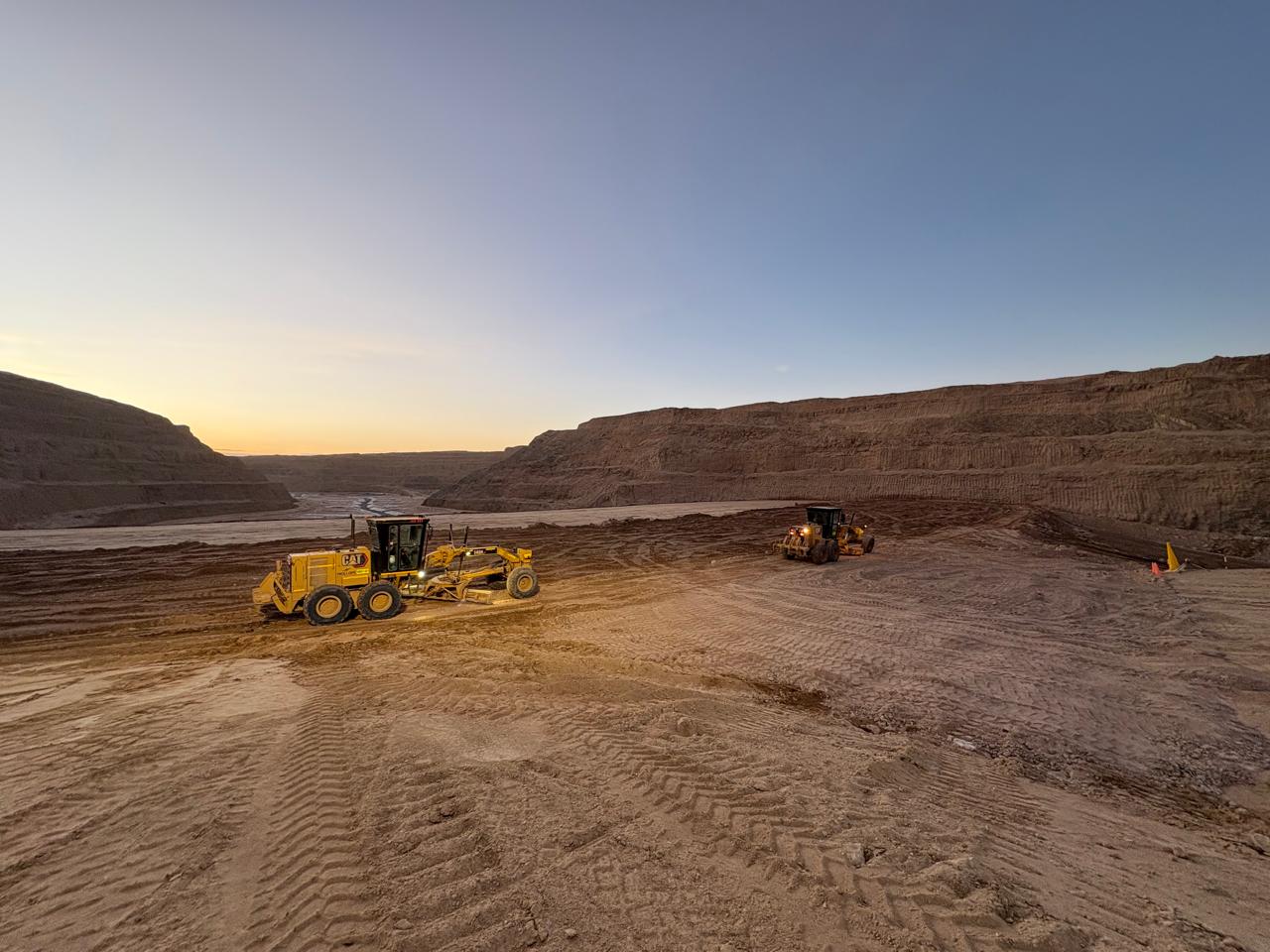 Haul road and highwall in an open-pit operation under clear sky